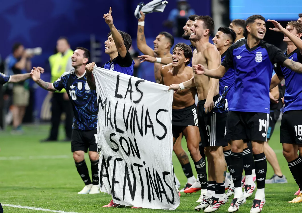 Message politique après la victoire en football ; un drapeau revendiquant la souveraineté des îles Malouines est brandi par des joueurs argentins.
